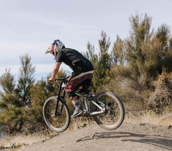 Man doing little jump on his mountain bike.