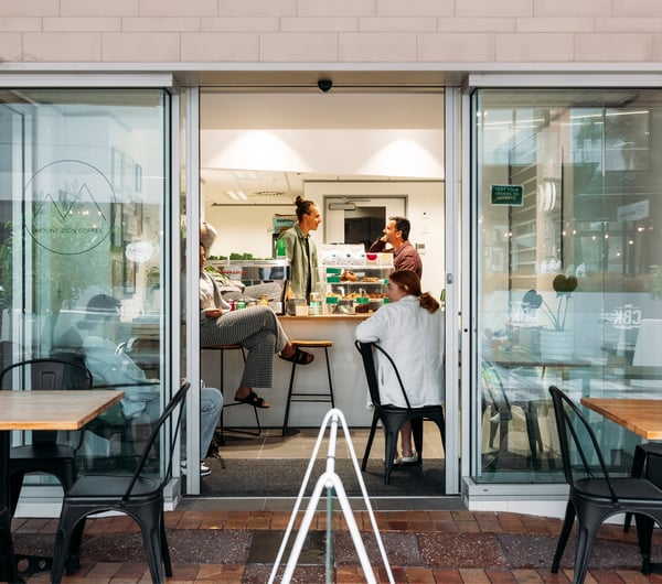 Customers dining inside a small cafe at dawn.