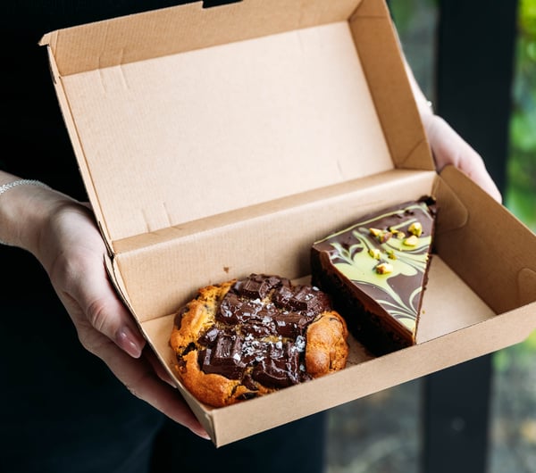 A cookie and slice in a box from Neverland Cakes.