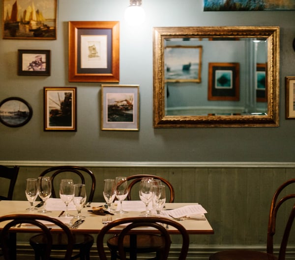 Table by photo frames on wall.