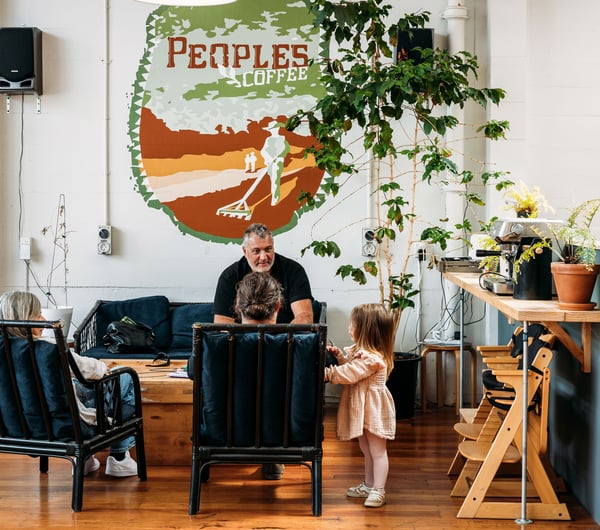 A man with child sitting on a couch at Peoples Coffee in Wellington, New Zealand.
