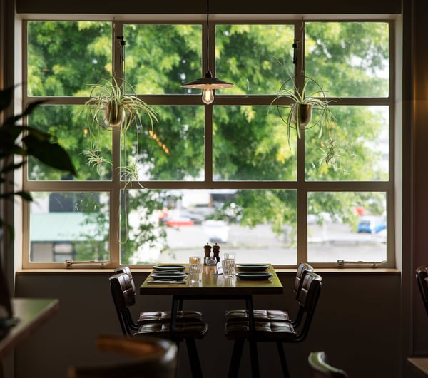 A table setting underneath a window looking out towards a sunny Rotorua street.