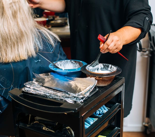 Woman using colour dye in bowls.