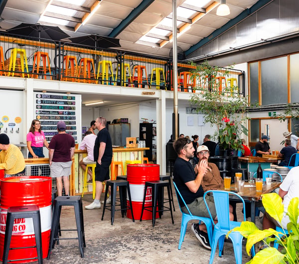 Groups of people drinking inside Renegade Brewing Co's industrial space in Christchurch