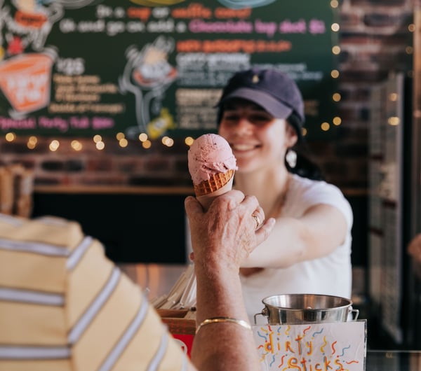 Woman handing customer an ice cream.