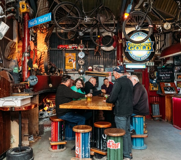 A group of men sitting around a high table in a pub.