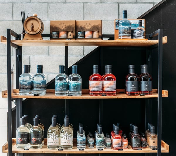 A close up of bottles of gin on shelves.