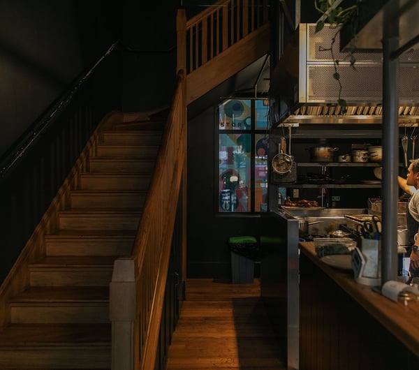 The kitchen at Story beside the wooden staircase up to the dining room.