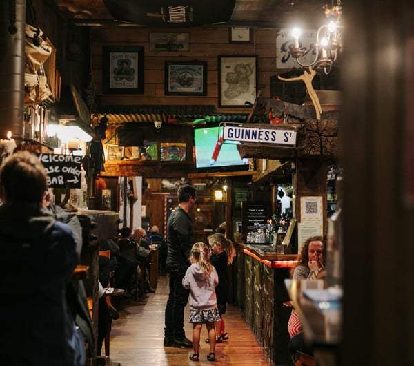 Man standing at the bar with his children at Strawberry Tree.