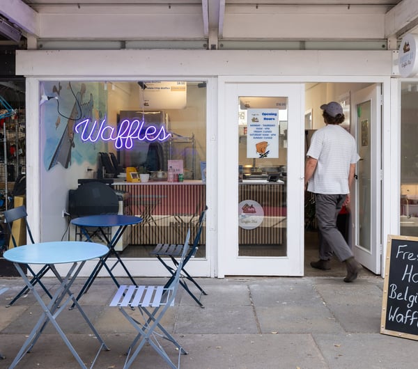 A customer walks in the front door of Sweet As Waffles.