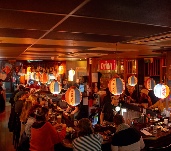 A packed restaurant on a dark night.