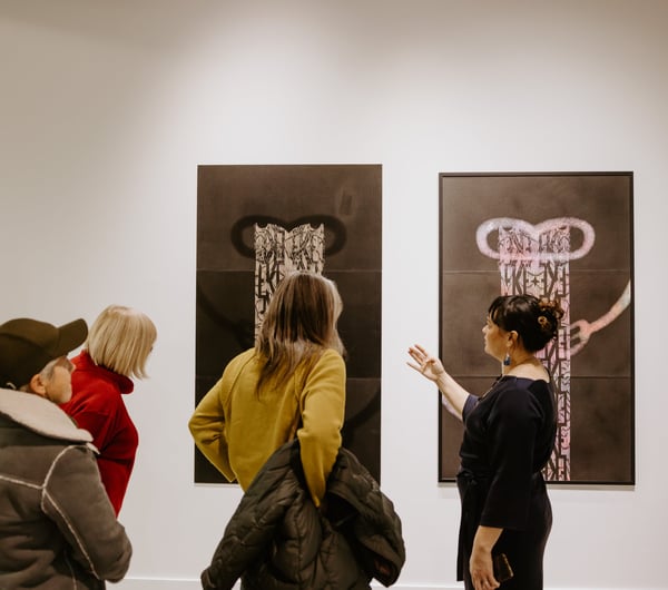 Gallery visitors looking at art on the walls at Te Atamira.