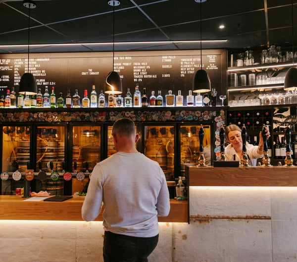 Man ordering a beer at the bar at Craft Embassy.