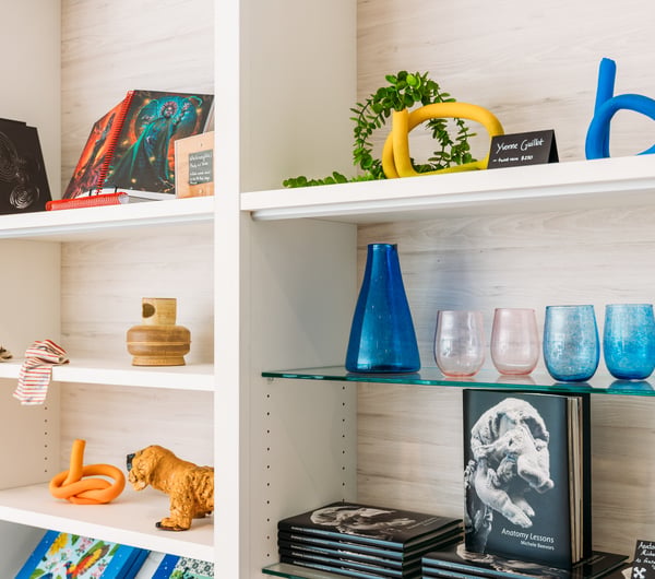 Cups and vases on display in a gallery gift shop.