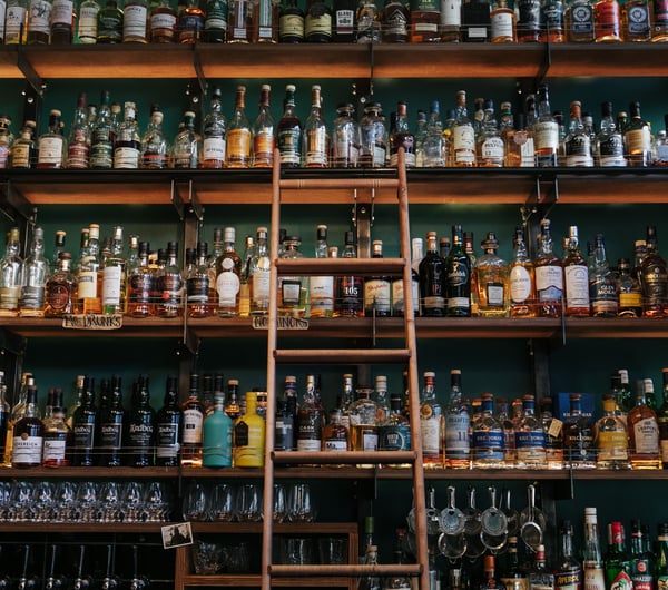 Close up of liquor bottles on a shelf.