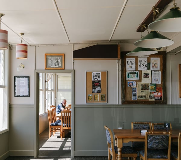 Seating area with noticeboard on the wall at The Moutere Inn, Nelson Tasman.