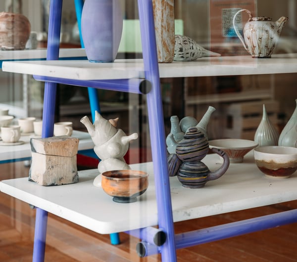 Pottery on tables behind a window.