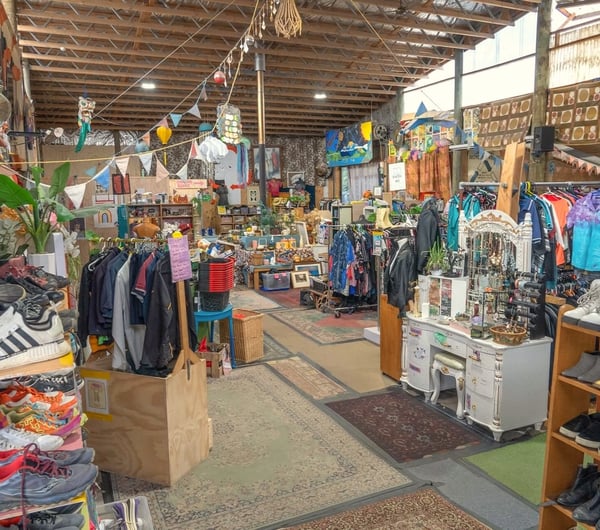 Main shop floor displaying second hand goods on racks and shelves at Wastebuster.