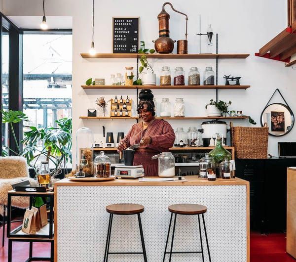 Woman standing behind counter making tea at Wellington Apothecary