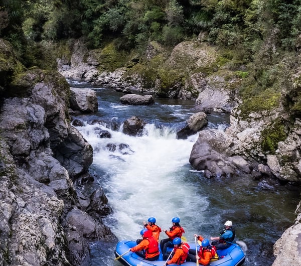 People in an orange boat on a river.