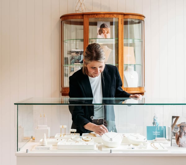 Woman reaching into jewellery cabinet at Whistle & Pop