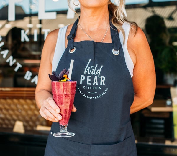 Woman holding a smoothie at Wild Pear Kitchen, New Plymouth.