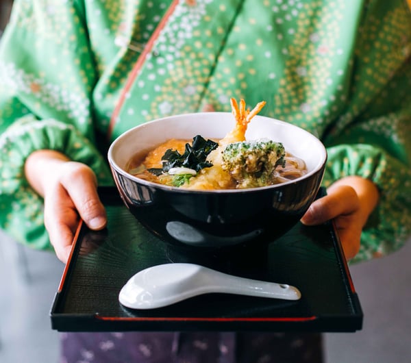 A waitress holding a bowl of food.
