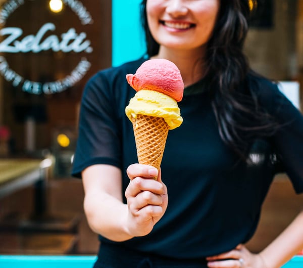 Woman holding ice cream on cone.
