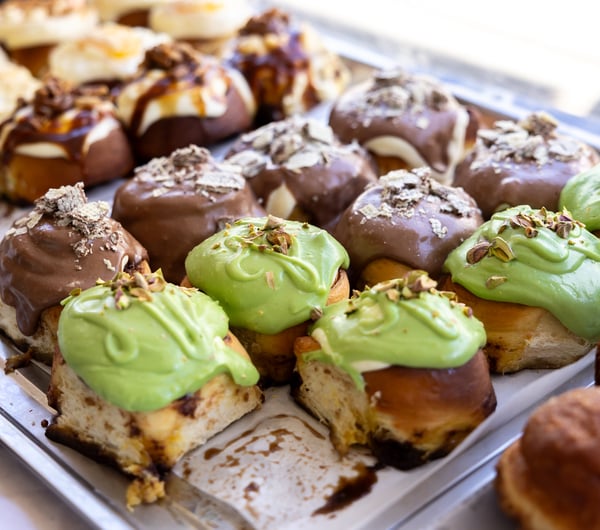 Tray of cinnamon rolls with colourful icing at Zoyi.