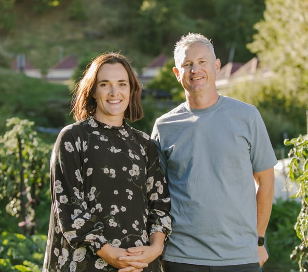 Hayley and Chris smiling at the camera from their garden.