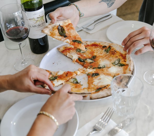 Diners enjoy a slice of pizza from one of the 10 best pizza spots in Christchurch.