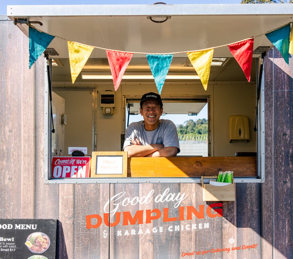 Food truck in a carpark with the road in the background.