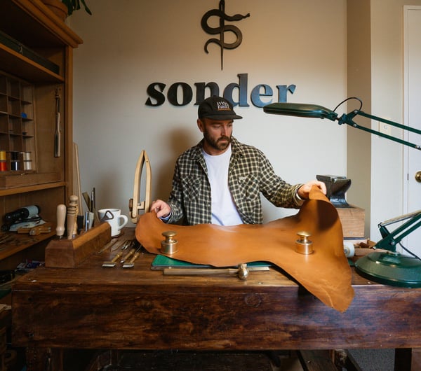 A man holding a large piece of kangaroo leather.