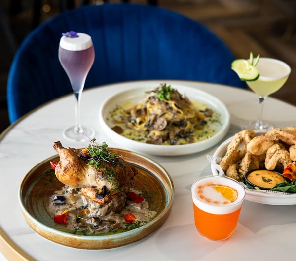 Plates of food and cocktails on a table.
