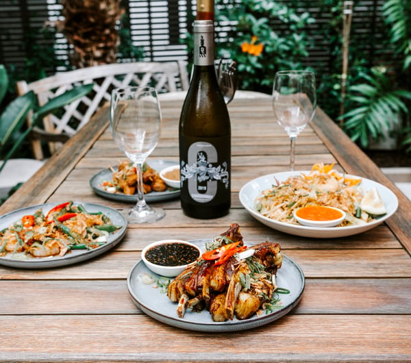 Plates of food on an outdoor table at Bandung Cafe.