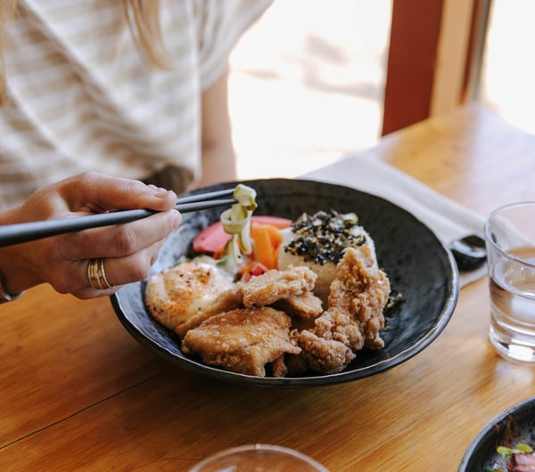 A customer is eating a dish at Sime's Kitchen.