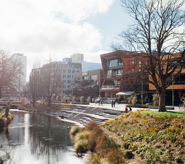 Buildings lined up alongside a river on a sunny day.