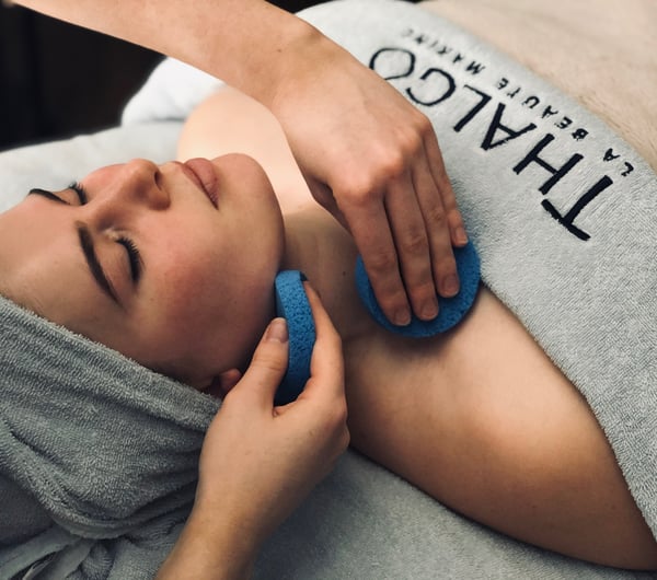 A woman draped in a blue towel getting a facial  at Total Body Concept in Christchurch.
