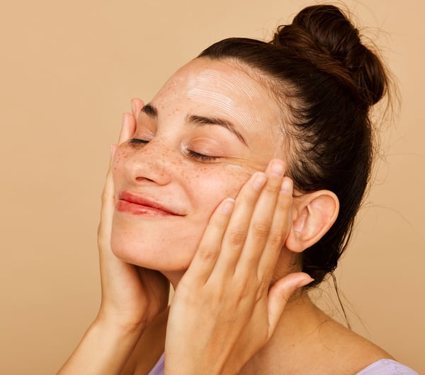 A woman pushing hands onto their face.