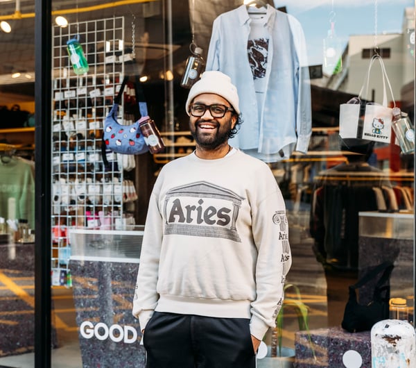 A man wearing a casual clothes smiling to camera outside a shop in Wellington.