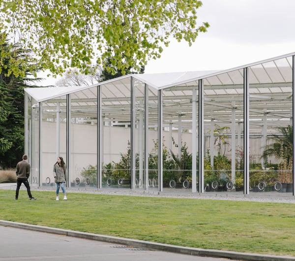 Two people spending time outside a glasshouse at Christchurch Botanic Gardens.