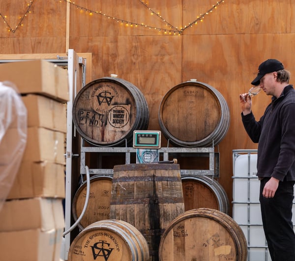 A distiller tasting and sampling a spirit in the workshop at The Spirits Workshop.