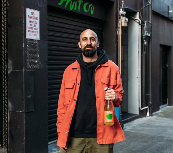 Cosmo holding a bottle of Fruit Cru.