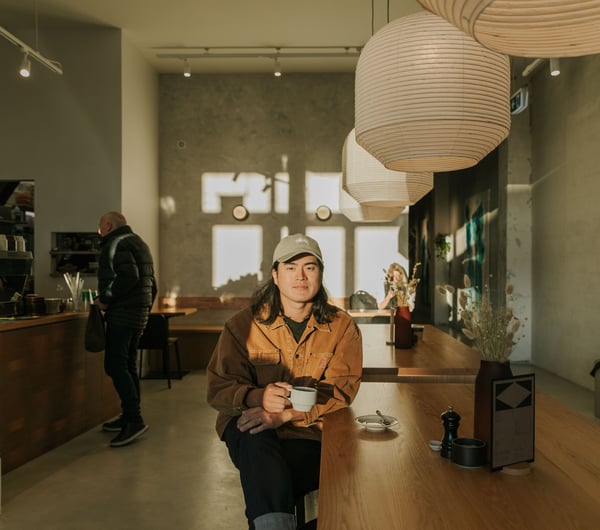 Christchurch cafe owner Sung Park drinking a coffee in the sun-drenched space of Akin