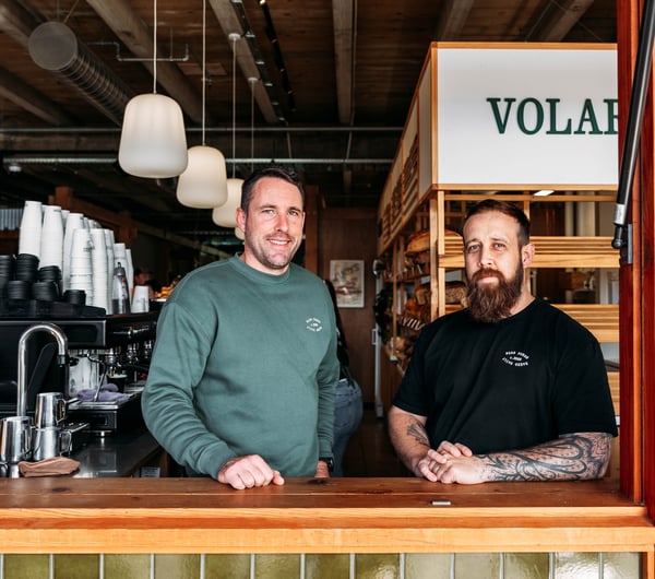 Two men smiling to camera.