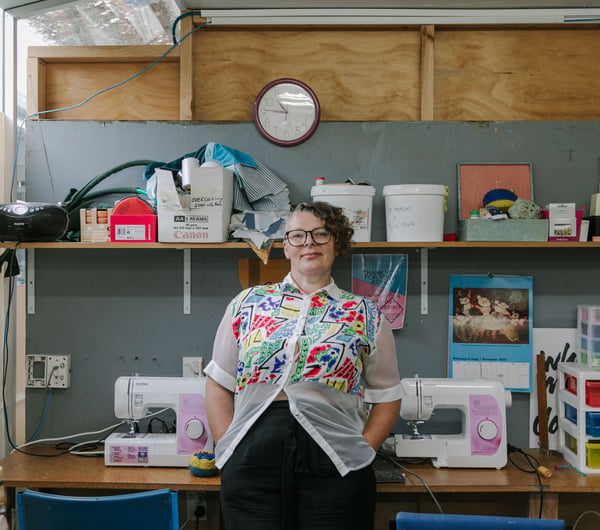Samantha Fay looking to camera inside her studio.