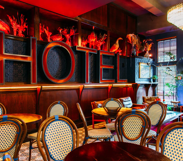 A massive red 'HOTEL' sign on a wall.