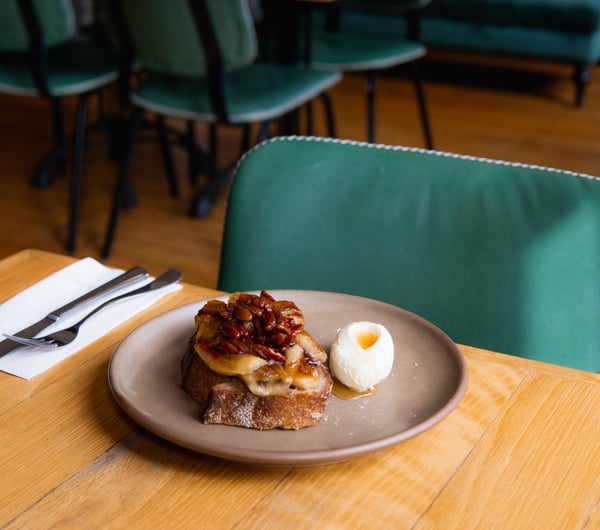 Elevated version of french toast with grilled bananas and a quenelle of cream on the side