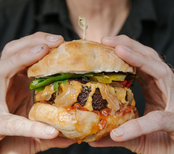 Close up of hands holding a vegan burger.
