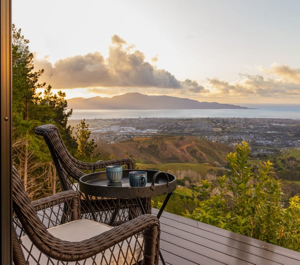Table and chairs on a balcony overlooking the coastline.